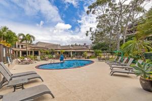 einen Pool mit Chaiselongue vor einem Haus in der Unterkunft Walkers Paradise Maui at Valley Isle Resort in Lahaina
