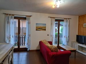 a living room with a red couch and sliding glass doors at Oasi Pieve in Pian di Scò +1 photo