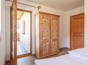 - une chambre avec un grand placard en bois et une fenêtre dans l'établissement Appartement Brixnerwirt II, à Brixen im Thale