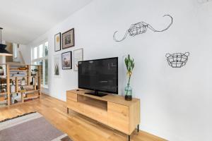 a living room with a flat screen tv on a wooden cabinet at Modern Amenities Downtown - Raleigh Craftsman in Raleigh