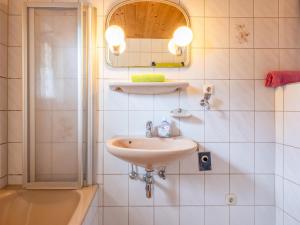 une salle de bain avec un lavabo, un miroir et une douche dans l'établissement Appartement Brixnerwirt I, à Brixen im Thale 24 autres photos