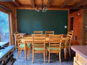 a dining room with a wooden table and chairs at Rustic Ridge Log Cabin: Hot Tub, Games, Views! in Mount Pocono +30 photos