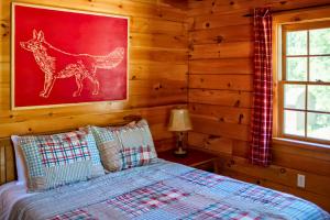 a bedroom with a bed and a painting of a giraffe at Rustic Ridge Log Cabin: Hot Tub, Games, Views! in Mount Pocono