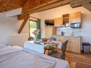 a bedroom with a bed and a table and a kitchen at Appartementkombination Brixnerwirt I II III und IV in Brixen im Thale