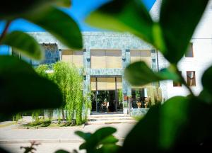 a building is shown through the leaves of a tree at Hotel Los Sauces in Cafayate