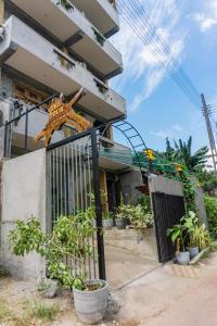 a house with a gate and potted plants at Tour Apartments in Weligama