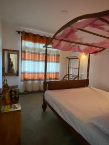 a bedroom with a canopy bed and a window at Tour Apartments in Weligama +20 photos