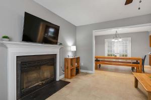 ローリーにあるNear Parks Trails & Downtown Raleigh Retreatのリビングルーム(暖炉、薄型テレビ付)