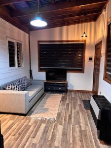 a living room with a couch and a flat screen tv at Bosque Patagonia Lodge in Puerto Natales