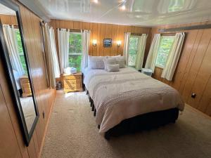 ein Schlafzimmer mit einem großen Bett und zwei Fenstern in der Unterkunft 26CM - private camp in Bretton Woods wifi AC private yard with great views in Carroll + 20 Fotos