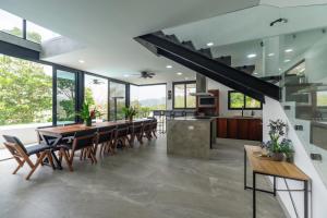 an open kitchen and dining room with a long table and chairs at Vida Palace in Jacó