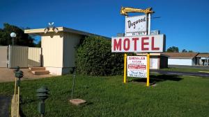 un cartel de motel en el césped junto a una calle en Dogwood Motel, en Mountain View