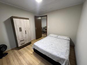 a bedroom with a bed and a cabinet in it at Casa Alto da Glória in Curitiba