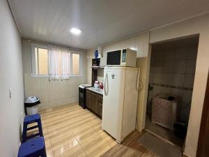 a small kitchen with a refrigerator and a microwave at Casa Alto da Glória in Curitiba