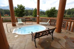 a jacuzzi tub on a patio with a bench at Fernie Stanford Resort in Fernie