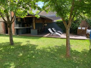 a group of chairs sitting on a patio in a yard at Maison années 30 avec jardin, piscine, proximité Loire, 4 chambres, vélos, idéale familles/amis - FR-1-590-261 in Bonny-sur-Loire
