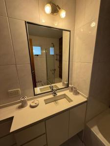 ein Badezimmer mit Waschbecken und großem Spiegel in der Unterkunft RECOLETA A 2 CUADRAS AVENIDA CORRIENTES ACOGEDOR Apartment in Buenos Aires