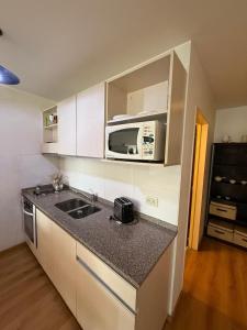 eine Küche mit Spüle und Mikrowelle in der Unterkunft RECOLETA A 2 CUADRAS AVENIDA CORRIENTES ACOGEDOR Apartment in Buenos Aires