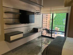 a bedroom with a flat screen tv on a wall at Increíble loft-Zona Rosa- CDMX- Loft 202 in Mexico City
