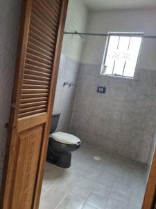 ein Badezimmer mit Toilette und Fenster in der Unterkunft Casa Marte rústica in Oaxaca de Juárez
