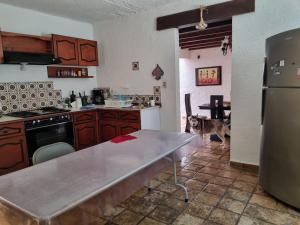 eine Küche mit einem Hund, der neben einem Kühlschrank steht in der Unterkunft Casa Marte rústica in Oaxaca de Juárez