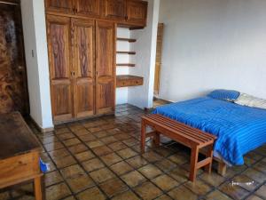 ein Schlafzimmer mit einem Bett und einem Holzschrank in der Unterkunft Casa Marte rústica in Oaxaca de Juárez