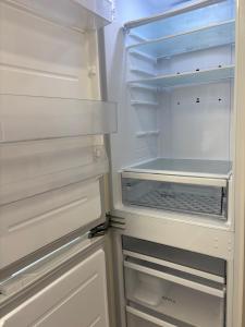 an empty refrigerator with its door open with its at g HOUSE in Busan