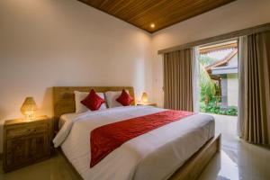 a bedroom with a large bed and a window at Pondok Sari in Ubud