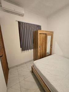 a small bedroom with a bed and a window at Gubug Semesta in Krambitan