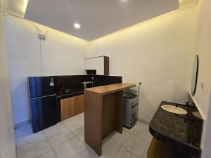 a kitchen with a counter and a blue refrigerator at Gubug Semesta in Krambitan