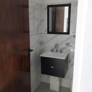 a bathroom with a sink and a mirror at APARTPIEDRAS-Cochera-Desayuno seco in Villa María
