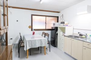 a kitchen with a table with chairs and a sink at AwesomeKurematsu in Hamamatsu