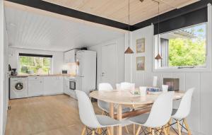 a kitchen and dining room with a table and white chairs at 2 Bedroom Pet Friendly Home In Knebel in Knebel