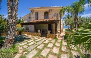 a house with a balcony and palm trees at Villa Oceania in Mandra Capreria +51 photos