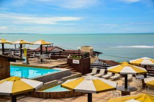 um resort com piscina e guarda-sóis e o oceano em Flat Pipa Oceano em Pipa