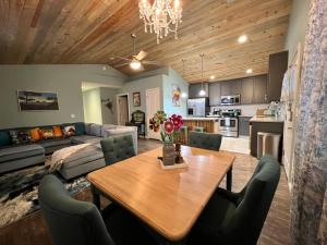 a dining room and living room with a table and a couch at Forest cottage - secluded, hot tub, walk to beach in Rockaway Beach