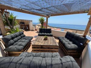 patio z kanapami i stołem oraz ocean w obiekcie LA GEODA vivienda vacacional turística 8 personas w mieście Villaricos