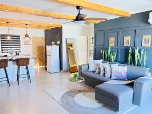 a living room with a blue couch and a kitchen at Kanana Villas Maun 2 bedroom apartment in Maun