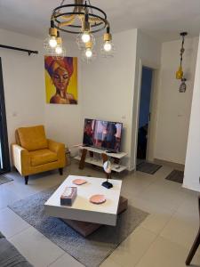 een woonkamer met een salontafel en een tv bij 1 Bedroom at Marassi Marina in El Alamein