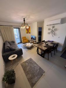 een woonkamer met een bank en een tafel bij 1 Bedroom at Marassi Marina in El Alamein