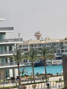 een groot gebouw met palmbomen ervoor bij 1 Bedroom at Marassi Marina in El Alamein