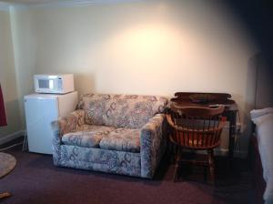 a living room with a couch and a chair and a microwave at Tides Motel - Hampton Beach in Hampton