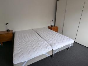 un lit blanc dans une chambre avec deux commodes dans l'établissement 5 person holiday home in Tranekær, à Tranekær
