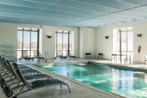 a large swimming pool with chairs in a building at Le Meridien Charlotte in Charlotte