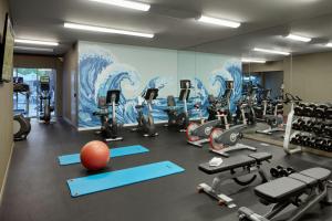 a gym with exercise equipment and a large mural at Hotel Paradox, Autograph Collection in Santa Cruz