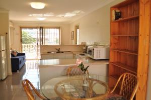 a kitchen with a glass table and chairs in a room at Isla House PA in Brisbane