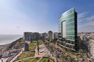 une ville avec un grand bâtiment à côté de l'océan dans l'établissement JW Marriott Hotel Lima, à Lima