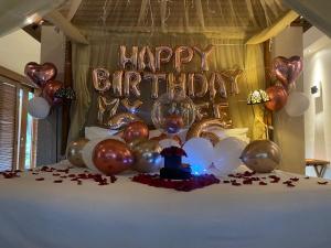 einen Tisch mit einem Geburtstagsschild und Ballons in der Unterkunft DISINI Luxury Spa Villas-CHSE Certified in Seminyak + 37 Fotos