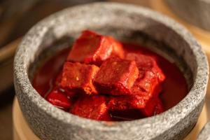 a gray bowl filled with red food on a table at 西安明城墙永兴坊桔子水晶酒店 in Xi'an
