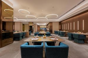 a restaurant with blue chairs and tables in a room at 西安明城墙永兴坊桔子水晶酒店 in Xi'an